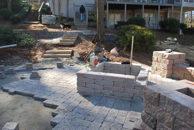 custom sized fire pit, seat wall with columns, and paver patio under construction