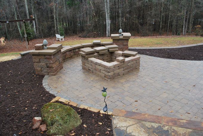 flagstone patio with a sitting wall and a firepit under construction