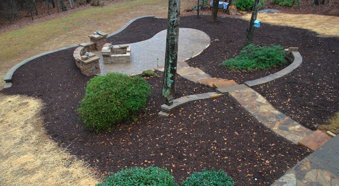 backyard natural stone patio with a decorative sitting wall and a fire pit