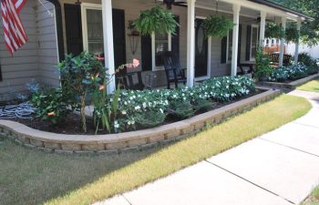 a nice looking border wall with plant bed at a front porch