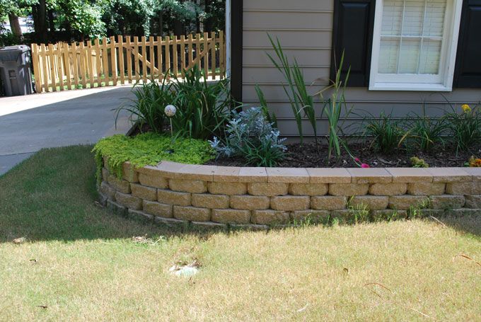 decorative retaining wall separating a planter from a front yard lawn