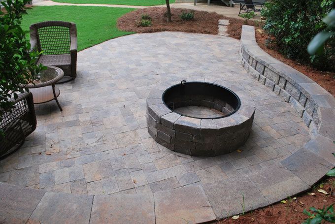 natural stone patio with a seat wall and a fire pit