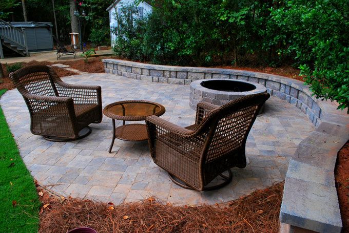 stone patio with a fire pit and seat wall