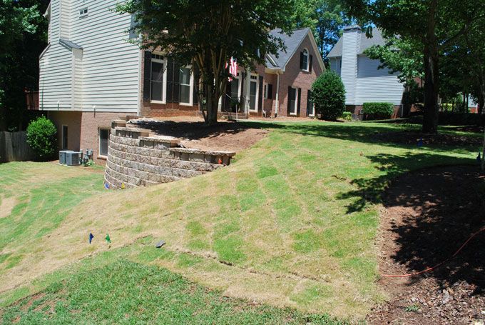 stepped retaining wall supporting a downhill lawn
