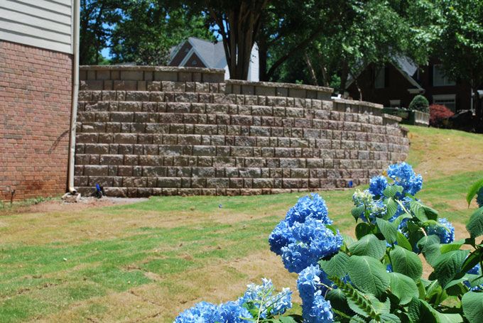 new stone retaining wall replacing the old failing railroad timber wall