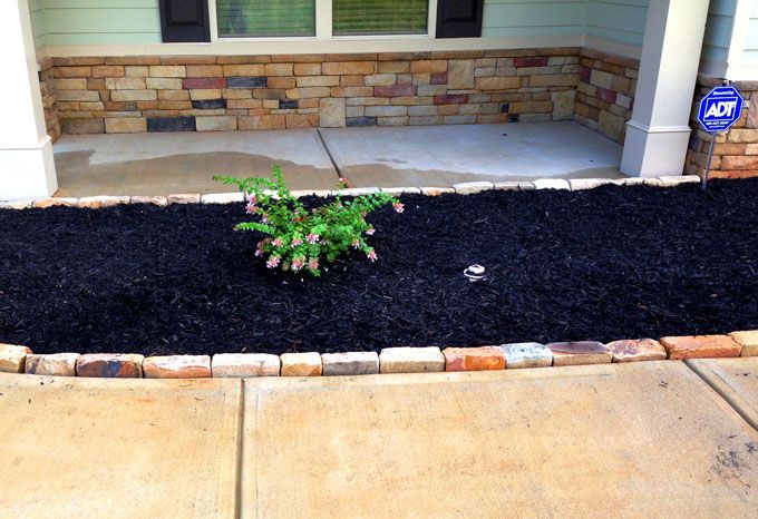 a planter with rock edging blends matching stone house details