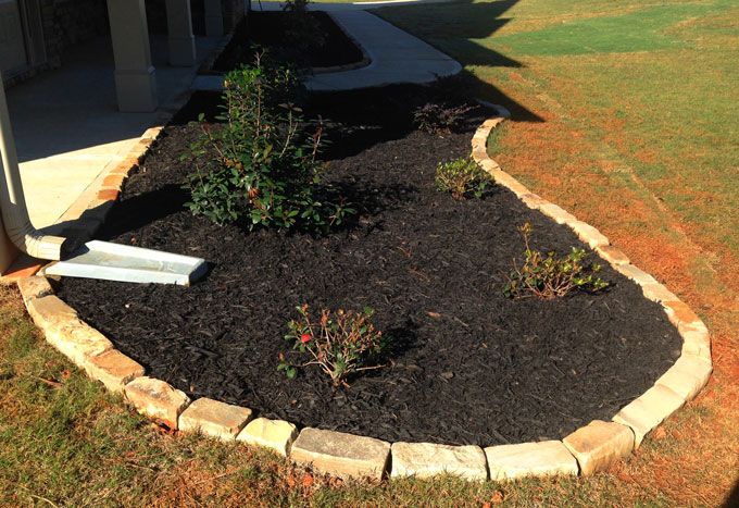 a planter with rock edging blends matching stone house details