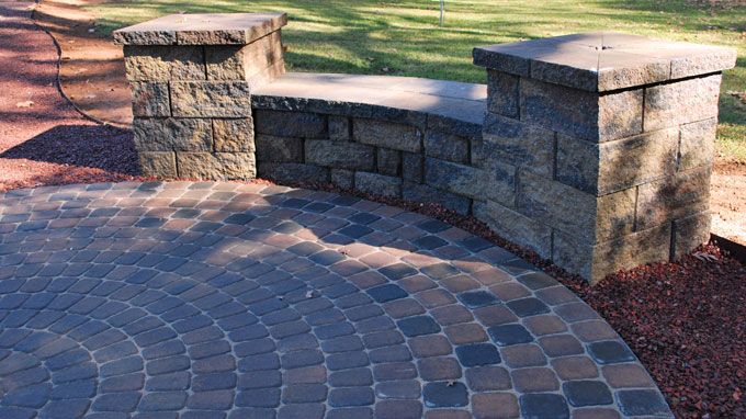 color blend circle patio with a seat wall that has columns on ends