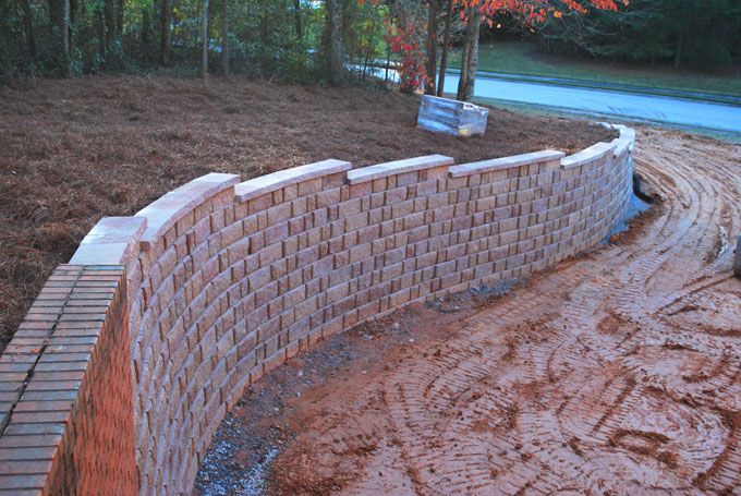 New large retaining wall before new sod installation next to it