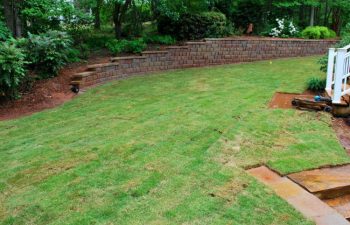 freshly installed sod and retaining wall in the backyard