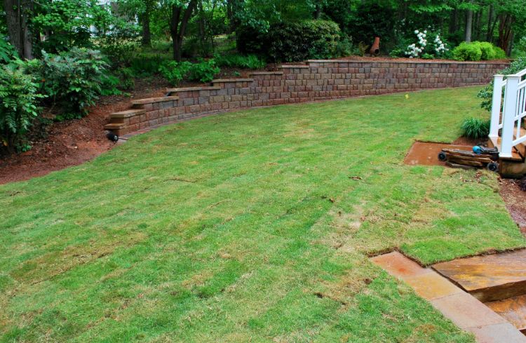 freshly installed sod and retaining wall in the backyard