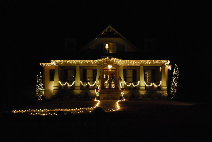 A house decorated with seasonal lighting and landscape lighting in front yard