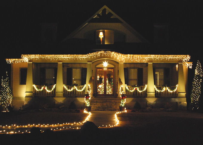 A house decorated with seasonal lighting and landscape lighting in front yard
