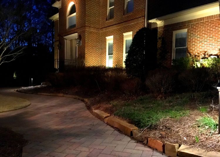 Landscape lights in front of the house creating light and shade patterns on the front wall