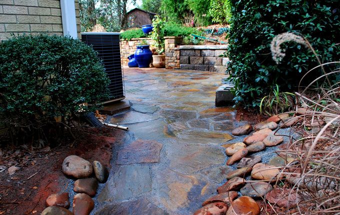 flagstone walkway with hardscapes on borders to control erosion and provide an escape for rain water