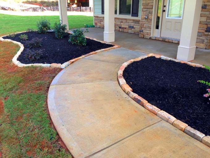 rock brick edging separating mulch from a walkway and lawn