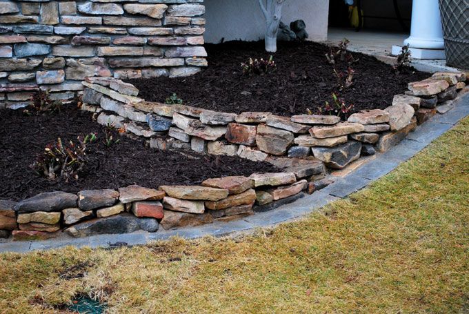 stack stone walls separating the mulched area from lawn