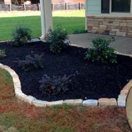 tumbled rock edging separating mulch and plants from a walkway and lawn